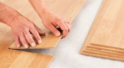 Pair of hands laying flooring